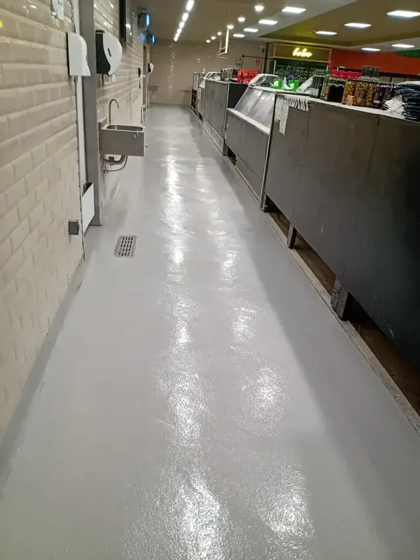 Corredor com piso cinza em área de cozinha
